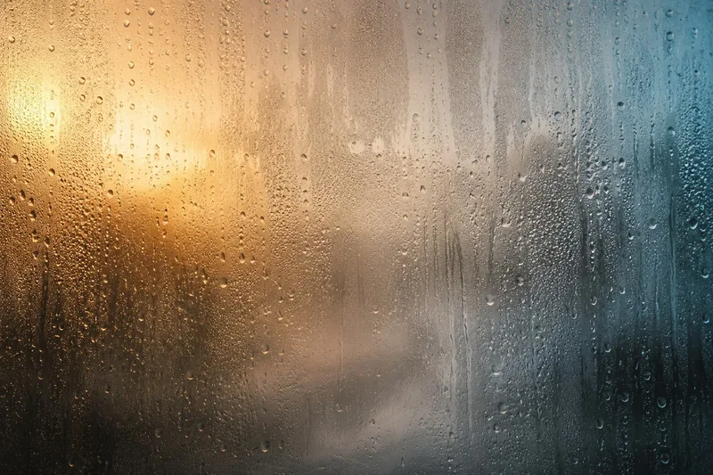 טיפות מים על זכוכית בגווני כתום וכחול, עיצוב מופשט עם טקסטורות ברורות.